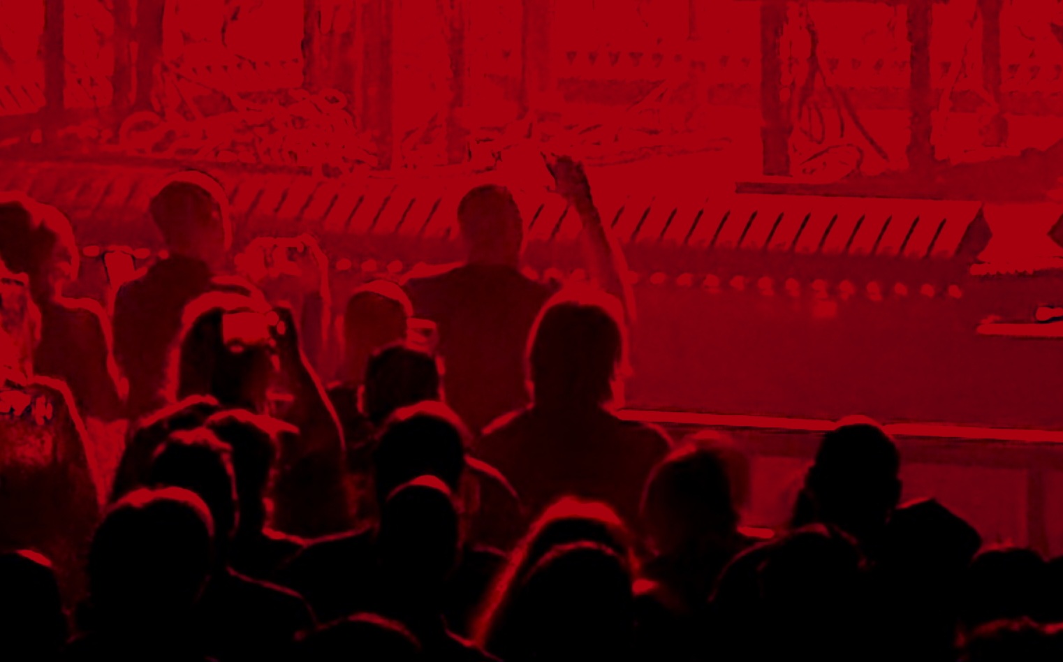 Red-tinted image of a crowd at a show